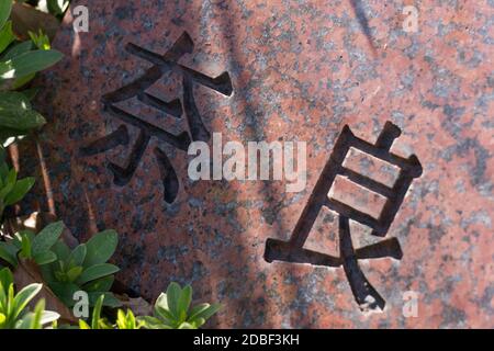 Die japanischen Schriftzeichen für Nara, die alte Stadt und ehemalige Hauptstadt in Zentral-Japan, in roten Granit geschnitzt Stockfoto