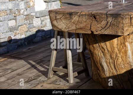 Typisch italienische Alpenlandschaft: Bänke und Tische aus einem einzigen Holzstamm vor einem Häuschen geschnitzt. Stockfoto