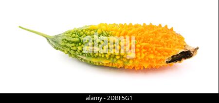 Bittere Melone reift von grün bis orange, mit einem schwarzen Fleck, wie Pod beginnt sich zu öffnen, isoliert auf einem weißen Hintergrund Stockfoto