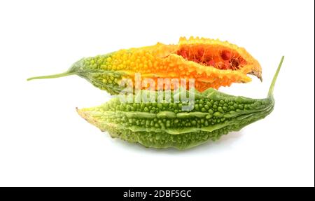 Zwei reife Bittermelonen - grün und überreife Orange, aufgespalten mit roten Samen im Inneren, isoliert auf weißem Hintergrund Stockfoto