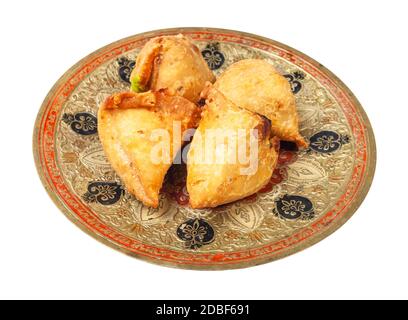 Indische Küche - Portion Gemüsesamosas (gebratenes Bohnengebäck, gefüllt mit Kartoffelbrei und Gemüse) auf Messingplatte auf weißem Backgroun isoliert Stockfoto