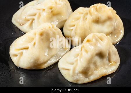 Portion Manti (Art Knödel in der türkischen Küche) auf schwarzem Teller Stockfoto