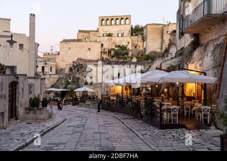 Matera, Italien - 20. September 2019: Abendansicht der Stadt Matera, Italien, mit den bunten Lichtern, die die Patios der Straßencafés im S hervorheben Stockfoto