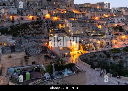 Matera, Italien - 20. September 2019: Abendansicht der Stadt Matera, Italien, mit den bunten Lichtern, die die Patios der Straßencafés im S hervorheben Stockfoto