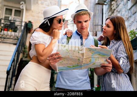 Glückliche Reisende Freunde Touristen Sightseeing mit Karte in der Hand Stockfoto