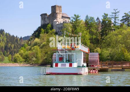 Niedzica, Polen - 18. Mai 2020: Burg Niedzica (Dunajec) aus dem 14. Jahrhundert, mittelalterliche Festung am Czorsztyn-See. Kreuzfahrtschiff am Yachthafen. Das ist es Stockfoto