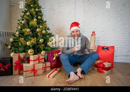 Glücklicher Mann auf Video-Anruf feiert weihnachten und Neujahr online zu Hause allein im Lockdown. Webcam-Ansicht im Hochformat. Virtuelle Feier und COVID-19 New N Stockfoto