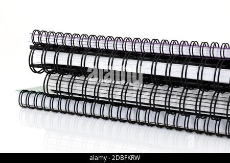 Ein Stapel spiralgebundener Notizbücher auf Weiß Stockfoto