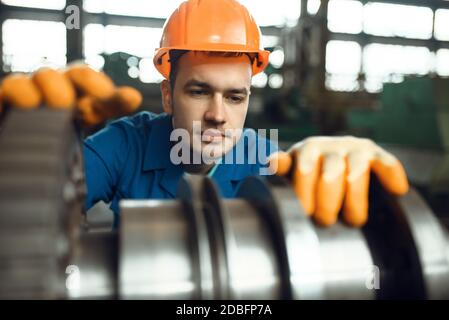 Männlicher Ingenieur arbeitet mit Turbine im Werk. Industrielle Produktion, Metallbearbeitung, Herstellung von Kraftmaschinen Stockfoto