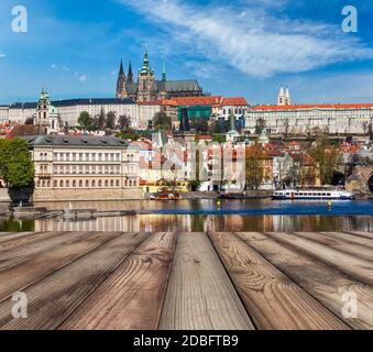 Holzbohlen mit Blick auf die Prager Karlsbrücke über die Moldau und Gradchany (Prager Burg) und den St. Veitsdom im Hintergrund Stockfoto