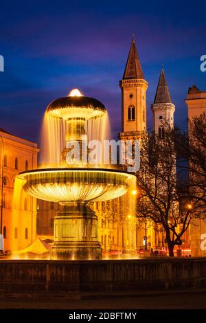 Brunnen im Geschwister-Scholl-Platz und St. Ludwigskirche am Abend. München, Bayern, Deutschland Stockfoto