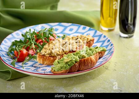 Croissant, Ei, Avocado, Rucola, Kirsche, Trüffel. Frühstücksangebot. Stockfoto