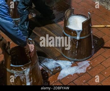 Traditionelle Zoigl Brauerei. Die Zoigl Original-Würze wird mit traditionellen Holzeimern in Falkenberg, Deutschland, lebhaft in den Tanker gefüllt Stockfoto