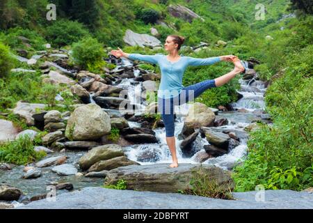 Yoga im Freien - Frau macht Ashtanga Vinyasa Yoga Balance Asana Utthita Hasta Padanguschthasana - Erweiterte Hand-zu-Big-Toe Pose Position Haltung outdoo Stockfoto