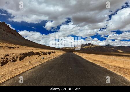 Reise vorwärts Konzept Hintergrund - Straße auf Ebenen im Himalaya mit Bergen und dramatischen Wolken. Manali-Leh Straße, Ladakh, Jammu und Kaschmir, Indien Stockfoto