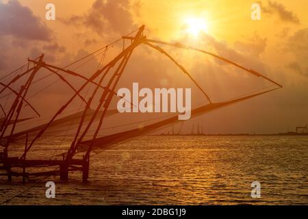 Kochi chinesische Fischnetze bei Sonnenuntergang in Fort Kochin, Kochi, Kerala, Indien Stockfoto