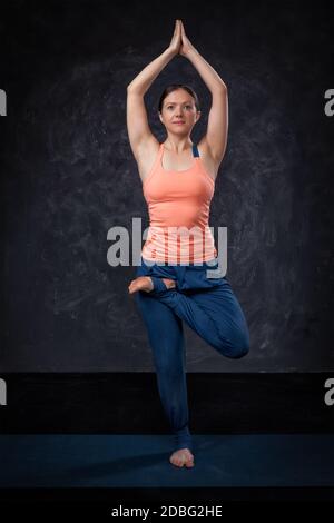 Schöne sportliche Passform Yogini Frau praktiziert Yoga Asana Vrikshasana - Baumhaltung Stockfoto