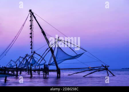 Kochi chinesische Fischnetze bei Sonnenuntergang in Fort Kochin, Kochi, Kerala, Indien Stockfoto