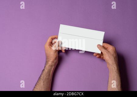 Männliche Hand hält einen Briefkopfpapier Umschlag, bearbeitbare Mock-up-Vorlage für Ihr Design, Auswahlpfad enthalten Stockfoto