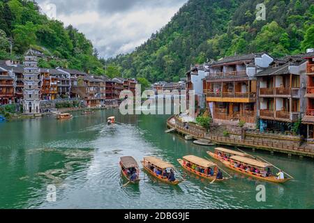 Chinesische Touristenattraktion Ziel - Feng Huang Altstadt (Alte Stadt Phoenix) Am Tuo Jiang Fluss mit Wanming Pagode Turm und Touristen Boote Stockfoto