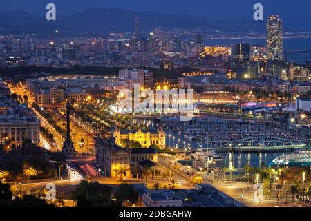 Luftaufnahme der Skyline von Barcelona mit Stadtverkehr und Hafen mit Yachten beleuchtet in der Nacht. Barcelona, Spanien Stockfoto