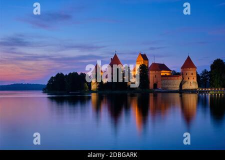 Trakai Insel Schloss im See Galve beleuchtet in der Dämmerung reflektiert in friedliches Wasser, Litauen Stockfoto