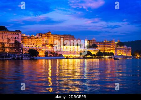 Blick auf berühmte romantische Luxus Rajasthan indischen touristischen Wahrzeichen - Udaipur City Palace in der Abenddämmerung mit dramatischen Himmel - Panoramablick. Uda Stockfoto