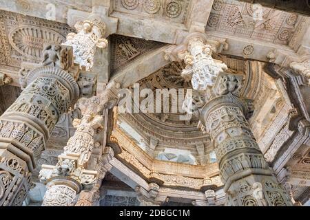 Säulen Säulen Säulen der schönen Ranakpur Jain Tempel oder Chaturmukha Dharana Vihara. Marmor alten mittelalterlichen geschnitzten Skulptur Schnitzereien des heiligen Ort Stockfoto