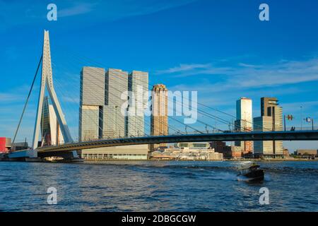 Erasmusbrücke über den Fluss Nieuwe Maas bei Sonnenuntergang mit Schnellboot unter der Brücke. Rotterdam, Niederlande Stockfoto