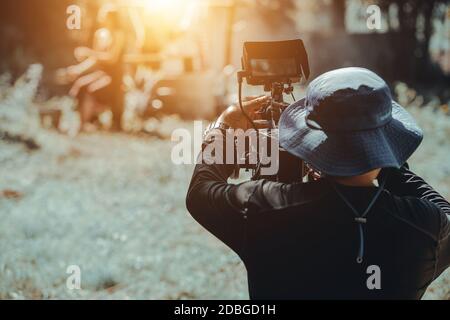 Hinter dem Kameramann, der die Kamera bedient, um einen Film zu drehen Stockfoto