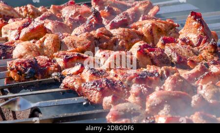 Wir braten Shish Kebabs, Grill, Grill im Hinterhof im Sommer an einem Wochenende. Der Küchenchef bereitet Fleisch in einem Café oder Restaurant zu. Frisch roh und gebraten por Stockfoto