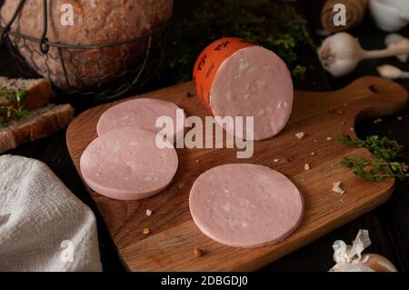 Gekochte Wurst mit Gewürzen und Kräutern auf einem Holzbrett Stockfoto