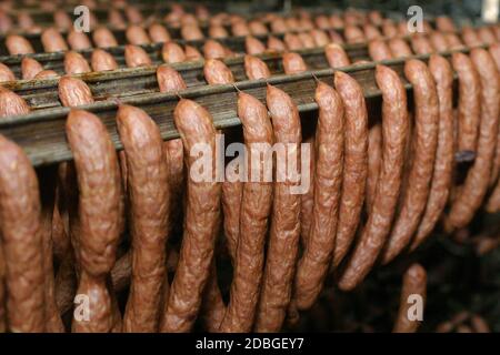 Produktionslinie für Wurst. Wurst auf der Theke für die Räucherei. Industrielle Herstellung von Würsten. Stockfoto