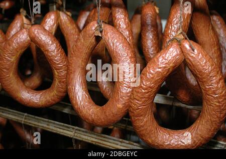 Produktionslinie für Wurst. Wurst auf der Theke für die Räucherei. Industrielle Herstellung von Würsten. Stockfoto