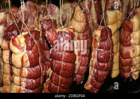 Produktionslinie für geräuchertes Fleisch. Fleisch auf der Theke für die Räucherei. Stockfoto