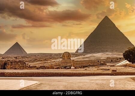 Geschnitzte große Sphinx vor der Pyramide von Gizeh in Ägypten mit dramatischen gelben Himmel. Stockfoto