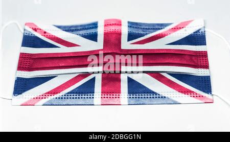 Chirurgische Maske mit der Nationalflagge Englands gedruckt. Pandemie covid-19 und vorbeugende Maßnahmen zur Bekämpfung der Ausbreitung des Virus Stockfoto