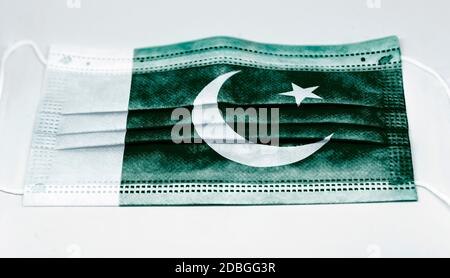 Chirurgische Maske mit der Nationalflagge Pakistans gedruckt. Pandemie covid-19 und vorbeugende Maßnahmen zur Bekämpfung der Ausbreitung des Virus Stockfoto