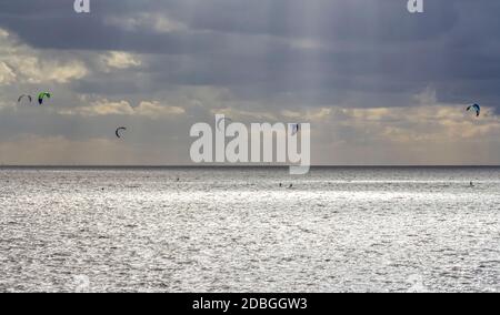 Dramatische beleuchtete Küstenlandschaft, darunter einige Kitesurfer bei Neuharlingersiel in Ostfriesland Stockfoto