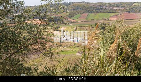 An einem Frühlingstag fährt ein öffentlicher Zug durch die portugiesische Landschaft Stockfoto