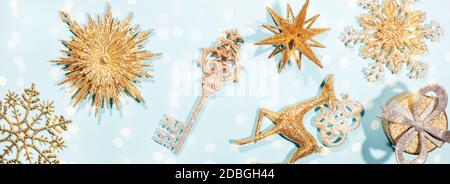 Golden schöne funkelnde Weihnachtsdekoration auf pastellblauem Hintergrund. Banner mit Beleuchtung Stockfoto