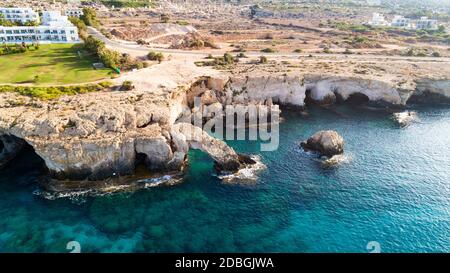 Luftaufnahme der Küste und Wahrzeichen Love Bridge, internationaler Skulpturen Park und Meereshöhlen, Cavo Greco, Ayia Napa, Famagusta, Zypern von oben. Stockfoto