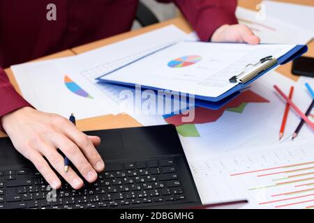 Nahaufnahme des Desktops mit Dokumenten, Laptop, Grafiken, Tabellen Stockfoto