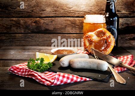 Traditionelles bayerisches oktoberfest-Ambiente mit Weißwurst, Brezel und Bier auf einem rustikalen Holztisch. Hintergrund für ein Gastronomiekonzept mit Stockfoto