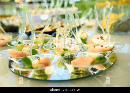 Buffettisch mit einer Anzeige von Lachs Meeresfrüchte Vorspeisen auf Kreisförmige Spiegel in einer niedrigen Winkel-dof-Ansicht bei Eine Veranstaltung oder ein Hochzeitsempfang mit Catering Stockfoto