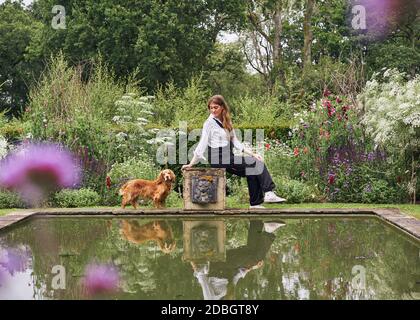 Innenarchitektin Flora Soames und ihr Hund Humbug, fotografiert in ihrem Wiltshire Zuhause. Flora trägt Latzhose der Carrier Company, darunter nichts Stockfoto