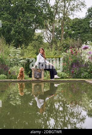 Innenarchitektin Flora Soames und ihr Hund Humbug, fotografiert in ihrem Wiltshire Zuhause. Flora trägt Latzhose der Carrier Company, darunter nichts Stockfoto