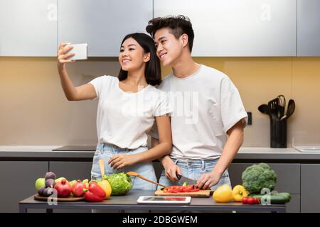 Glücklich Asiatische Paar Machen Selfie Kochen In Der Küche Zu Hause Stockfoto