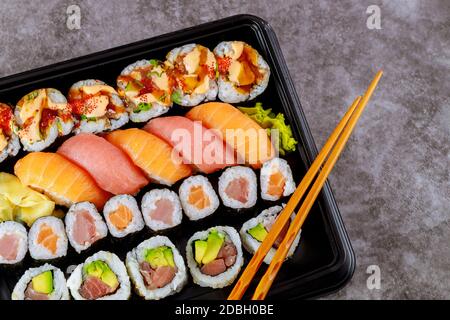 Auswahl an Sushi-Rollen auf einem schwarzen Tablett. Japanische Küche. Draufsicht. Stockfoto