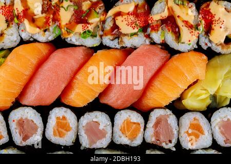 Set von köstlichen frischen Sushi-Rolle auf einem schwarzen Tablett. Japanische Küche. Draufsicht. Stockfoto